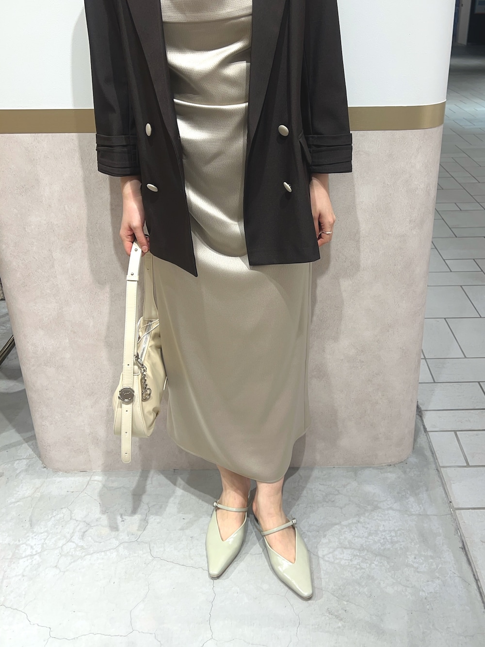 ベージュ系のワンピース、ブラウン系のテーラードジャケット、グリーン系のパンプスを着用したレディースの春コーディネートの4枚目の写真