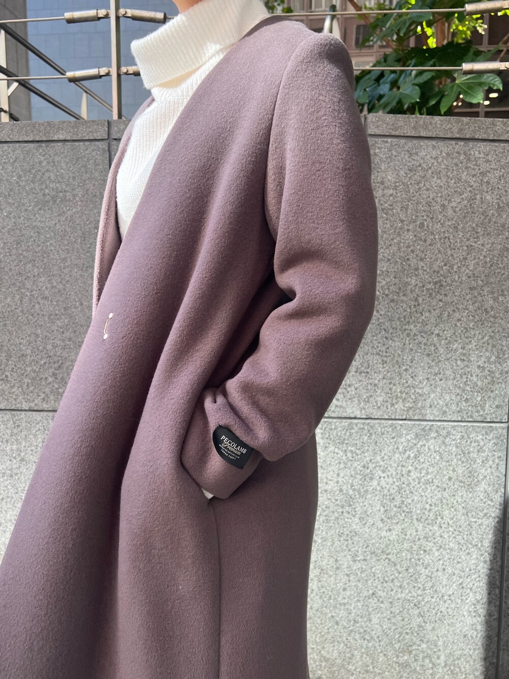 ベージュ系のブーツ、グレー系のスカート、ホワイト系のハンドバッグを着用したレディースの秋コーディネートの5枚目の写真