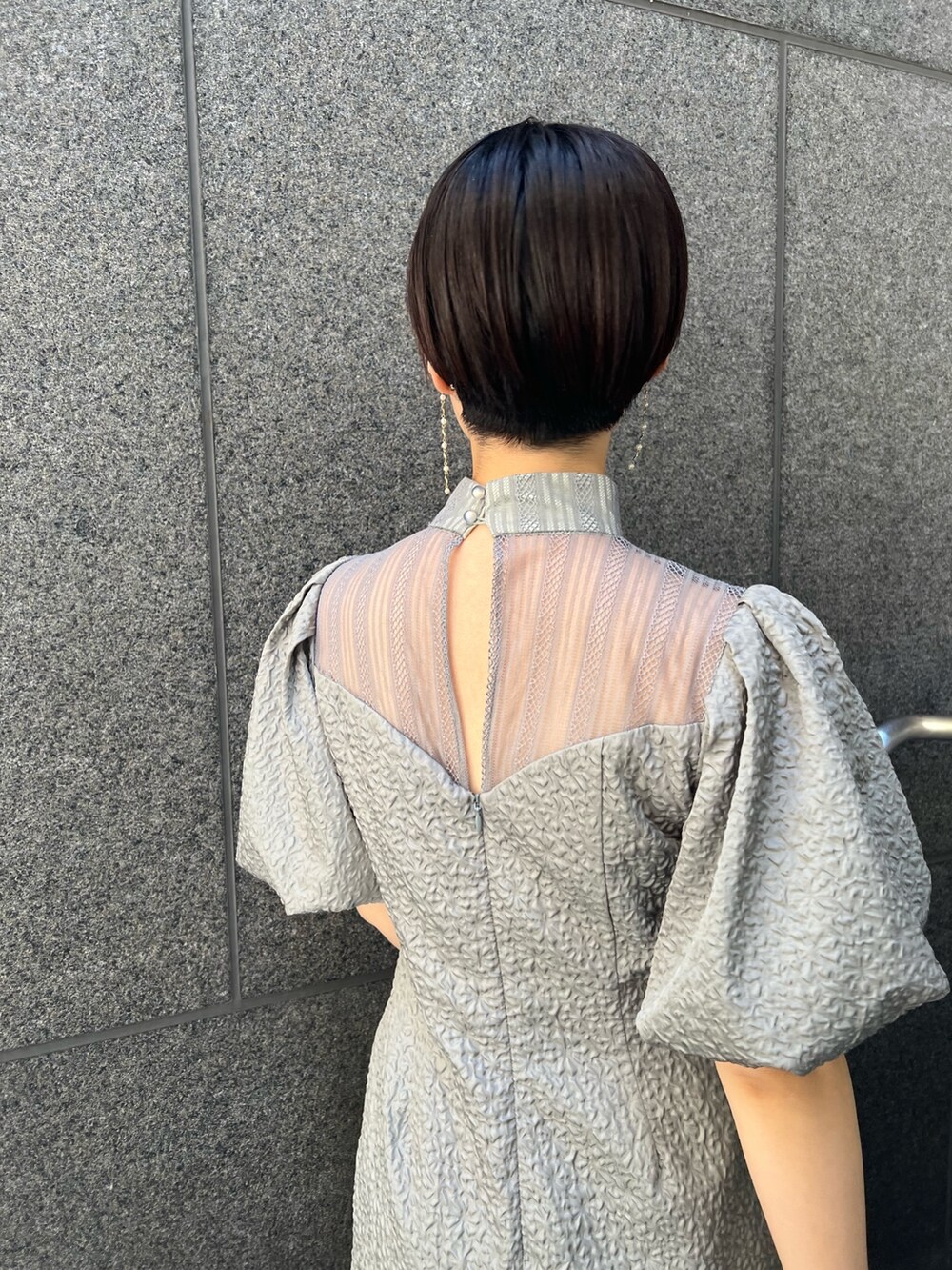 ブラック系のその他アウター、シルバー系のパンプス、グリーン系のドレスを着用したレディースの秋コーディネートの6枚目の写真