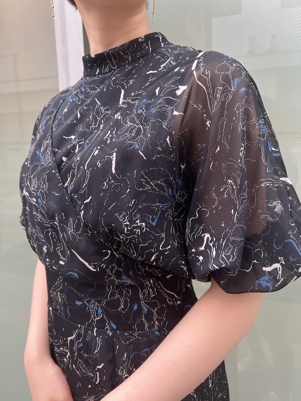 ベージュ系のサンダル、ホワイト系のハンドバッグ、ブラック系のワンピースを着用したレディースの夏コーディネートの3枚目の写真