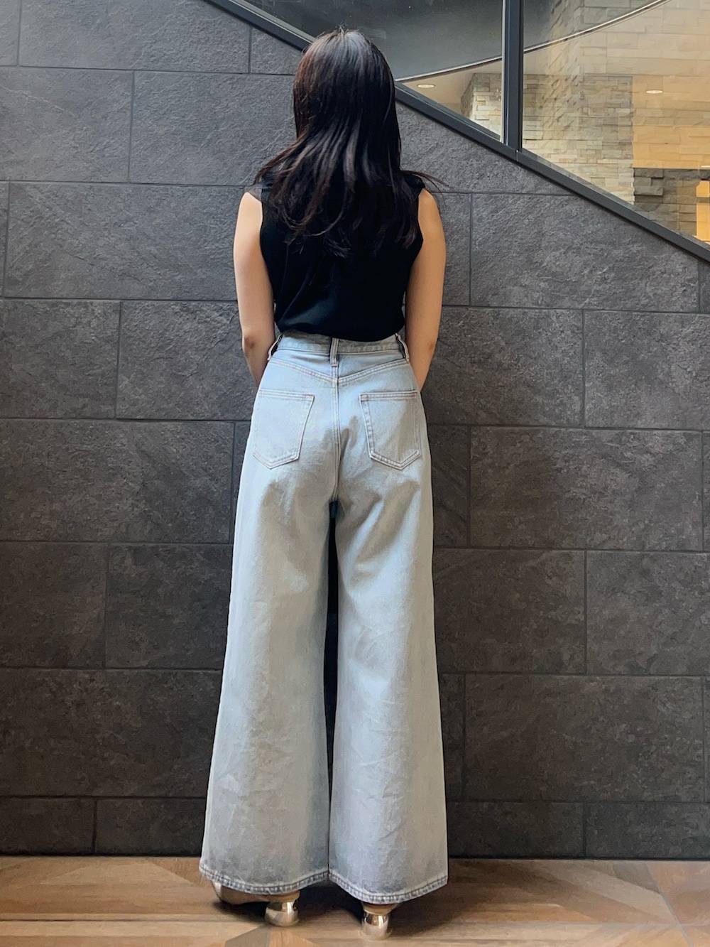 ブラック系のニット/セーター、ベージュ系のパンプス、ブラウン系のボストンバッグを着用したレディースの夏コーディネートの3枚目の写真