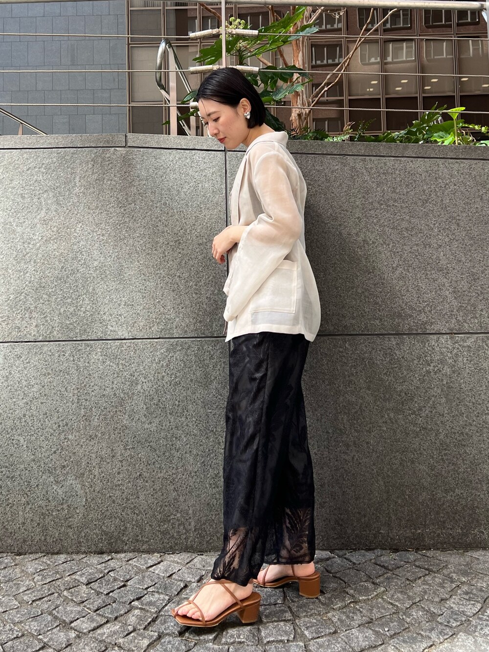 イエロー系のサンダル、ホワイト系のテーラードジャケット、ブラック系のつなぎ/オールインワンを着用したレディースの春コーディネートの2枚目の写真