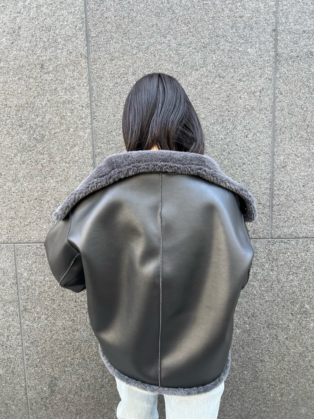 グレー系のムートンコート、ブルー系のデニムパンツを着用したレディースの冬コーディネートの4枚目の写真