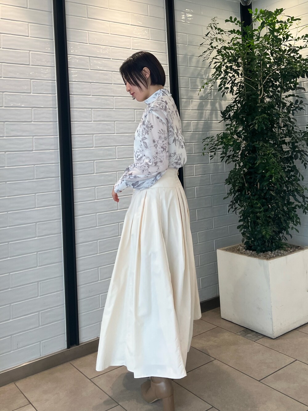 ホワイト系のスカート、ベージュ系のブーツ、ブラウン系のシャツ/ブラウスを着用したレディースの冬コーディネートの4枚目の写真