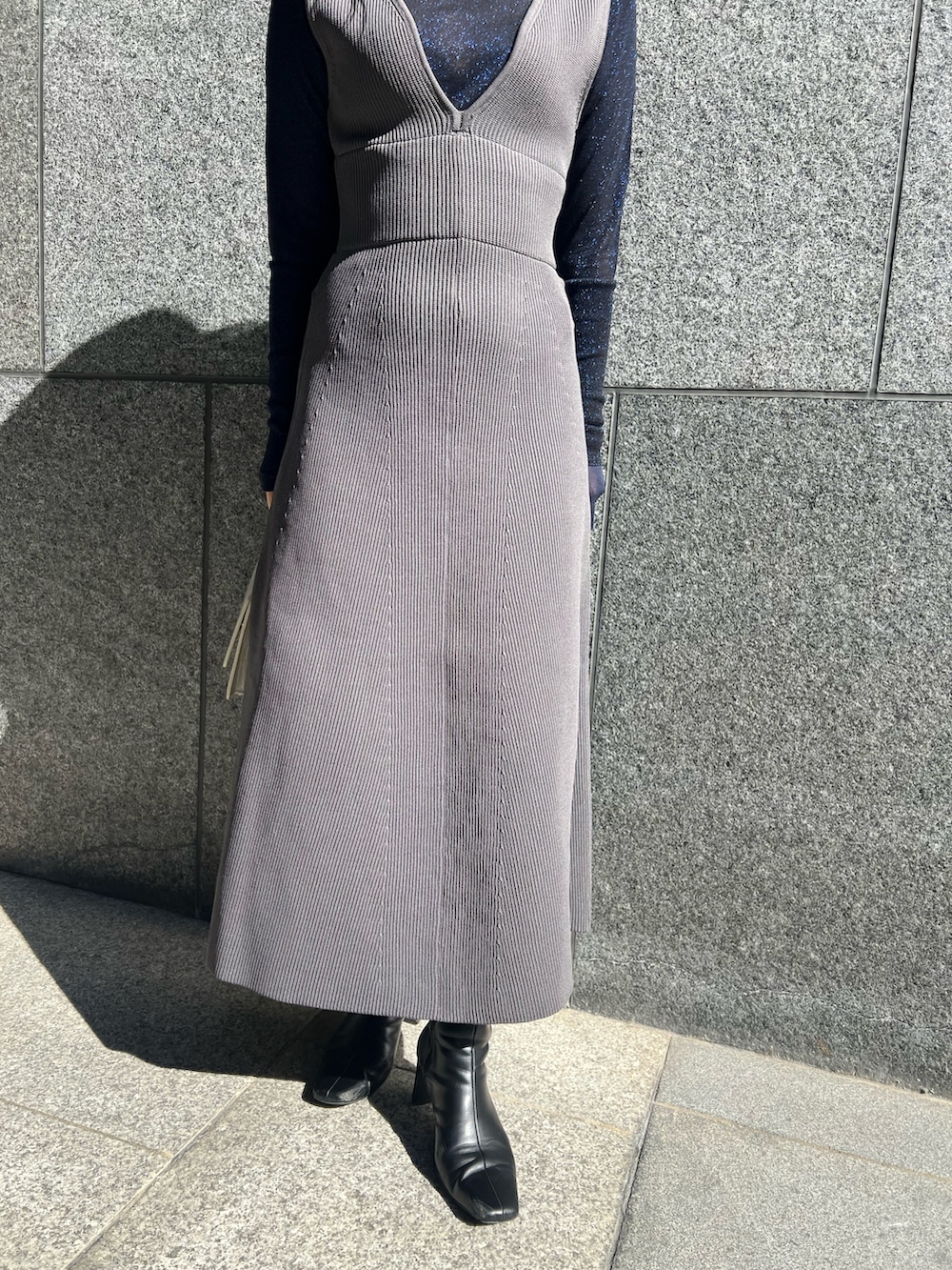 グレー系のTシャツ/カットソー、グレー系のカーディガン/ボレロ、グレー系のジャンパースカートを着用したレディースの秋コーディネートの5枚目の写真