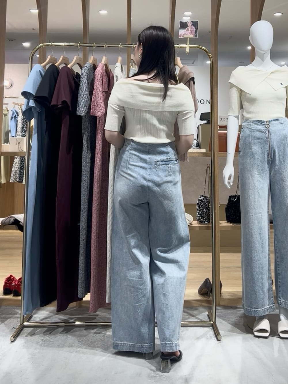 ホワイト系のニット/セーター、ブルー系のデニムパンツ、ブラック系のサンダルを着用したレディースの春コーディネートの3枚目の写真