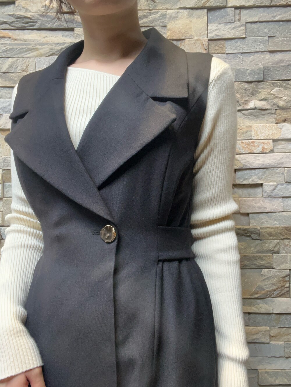 ブラック系のワンピース、ホワイト系のニット/セーター、ブラック系のブーツを着用したレディースの秋コーディネートの4枚目の写真