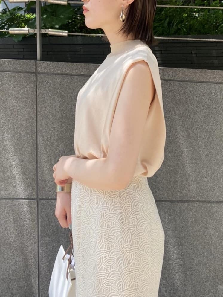 ベージュ系のニット/セーター、ホワイト系のハンドバッグ、ホワイト系のスカートを着用したレディースの夏コーディネートの4枚目の写真