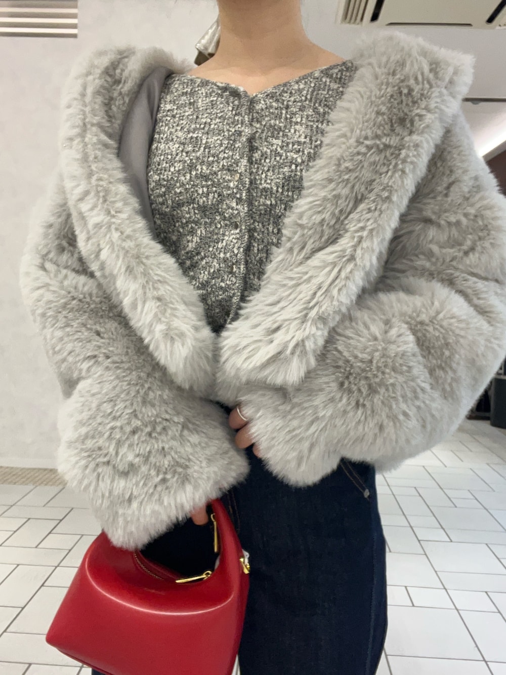 ブルー系のデニムパンツ、グレー系のその他アウター、グレー系のニット/セーターを着用したレディースの冬コーディネートの3枚目の写真