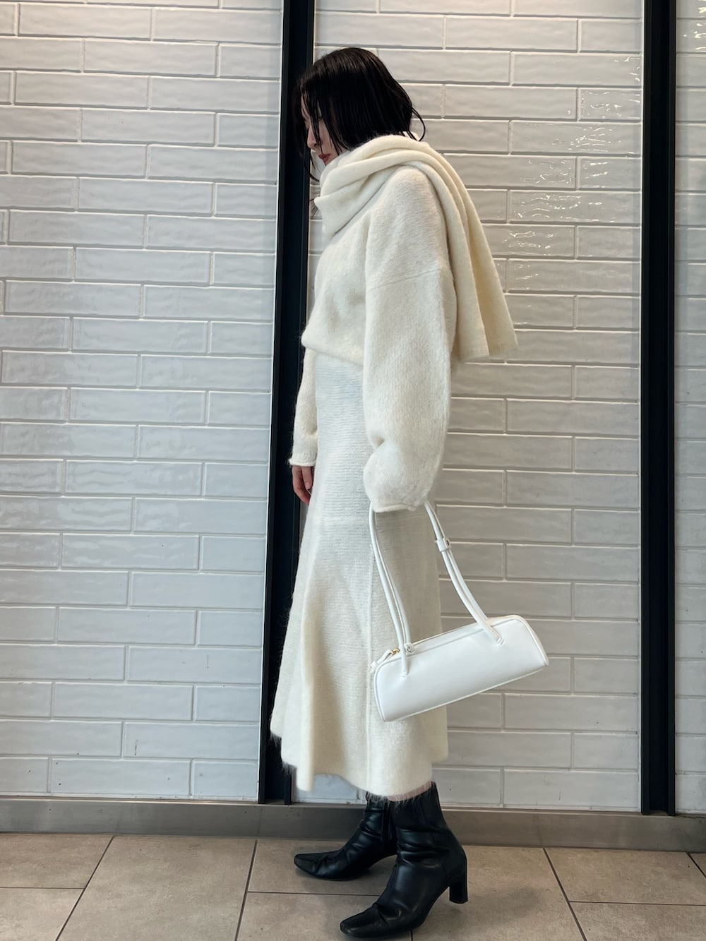 ホワイト系のスカート、ホワイト系のニット/セーター、ホワイト系のショルダーバッグを着用したレディースの秋コーディネートの2枚目の写真