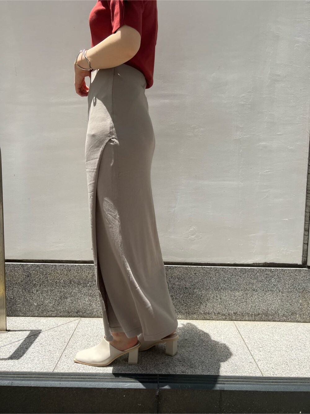 ベージュ系のハンドバッグ、ホワイト系のサンダル、ベージュ系のスカートを着用したレディースの夏コーディネートの8枚目の写真