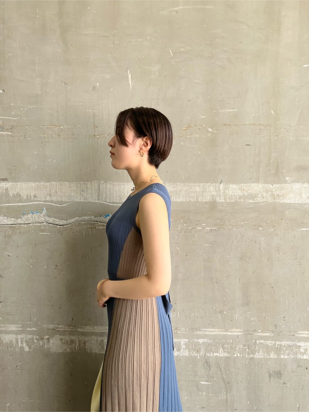 ホワイト系のハンドバッグ、ブルー系のワンピース、ゴールド系のピアス（両耳用）を着用したレディースの夏コーディネートの5枚目の写真