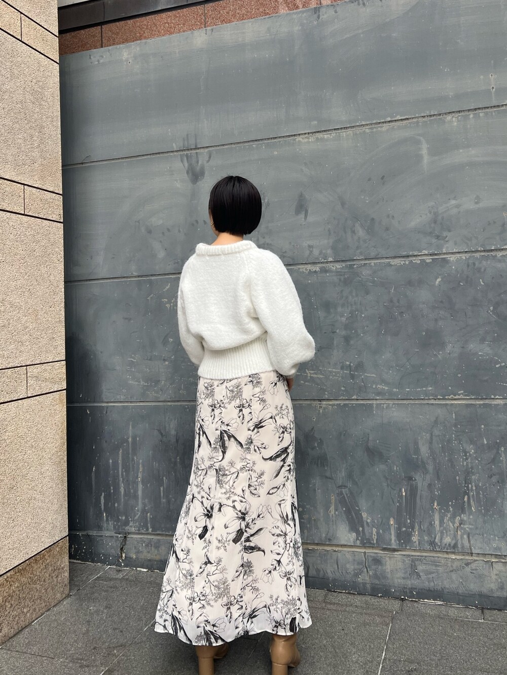 ベージュ系のブーツ、ブルー系のショルダーバッグ、ホワイト系のスカートを着用したレディースの冬コーディネートの2枚目の写真