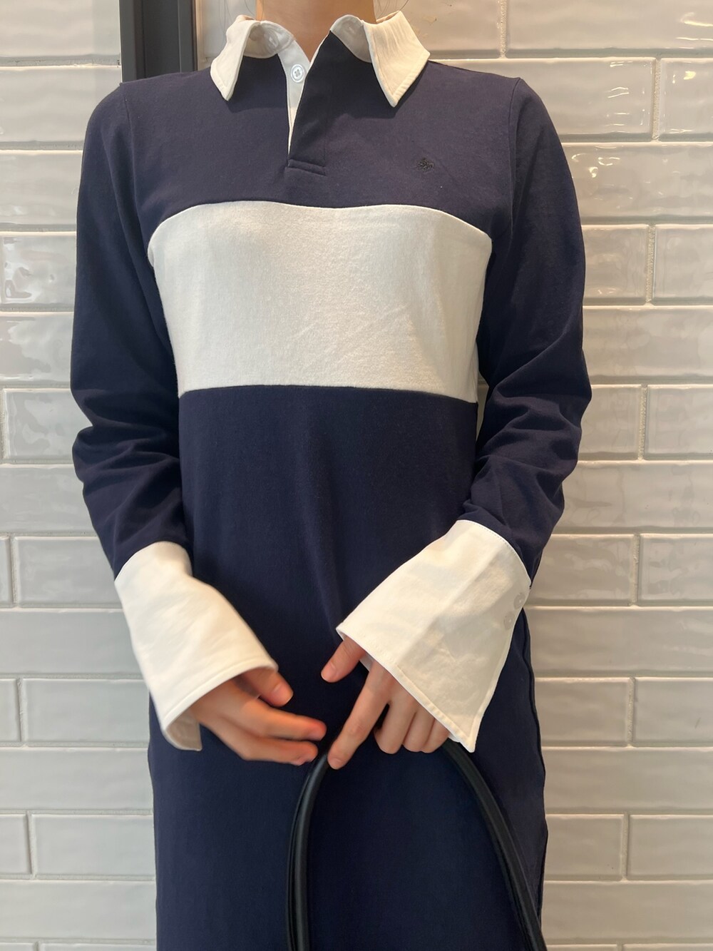 ブラック系のハンドバッグ、ブラック系のブーツ、ブルー系のワンピースを着用したレディースの秋コーディネートの5枚目の写真