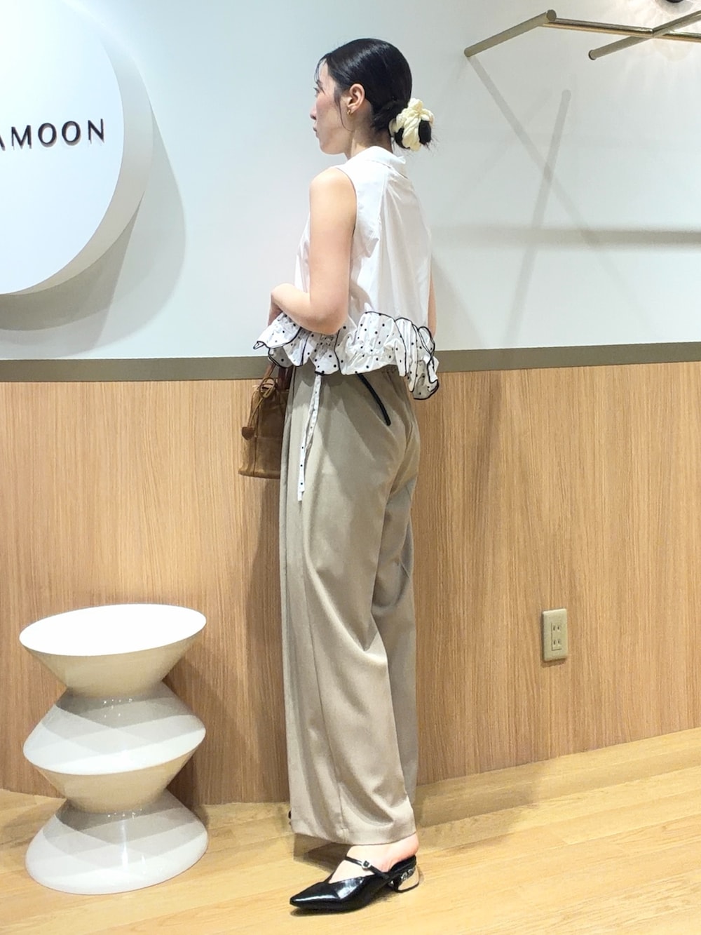 ベージュ系のその他パンツ、ホワイト系のシャツ/ブラウス、ブラウン系のハンドバッグを着用したレディースの夏コーディネートの2枚目の写真