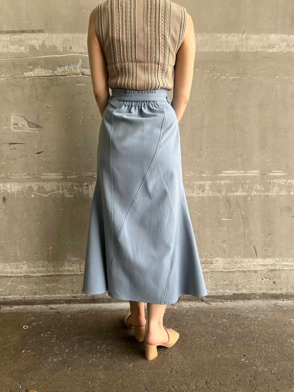 ベージュ系のニット/セーター、ブルー系のスカート、ベージュ系のサンダルを着用したレディースの夏コーディネートの8枚目の写真