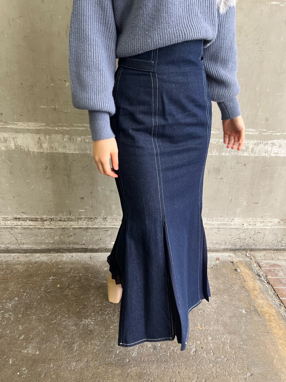 ベージュ系のブーツ、ブルー系のスカート、ホワイト系のダウンジャケット/コートを着用したレディースの冬コーディネートの9枚目の写真