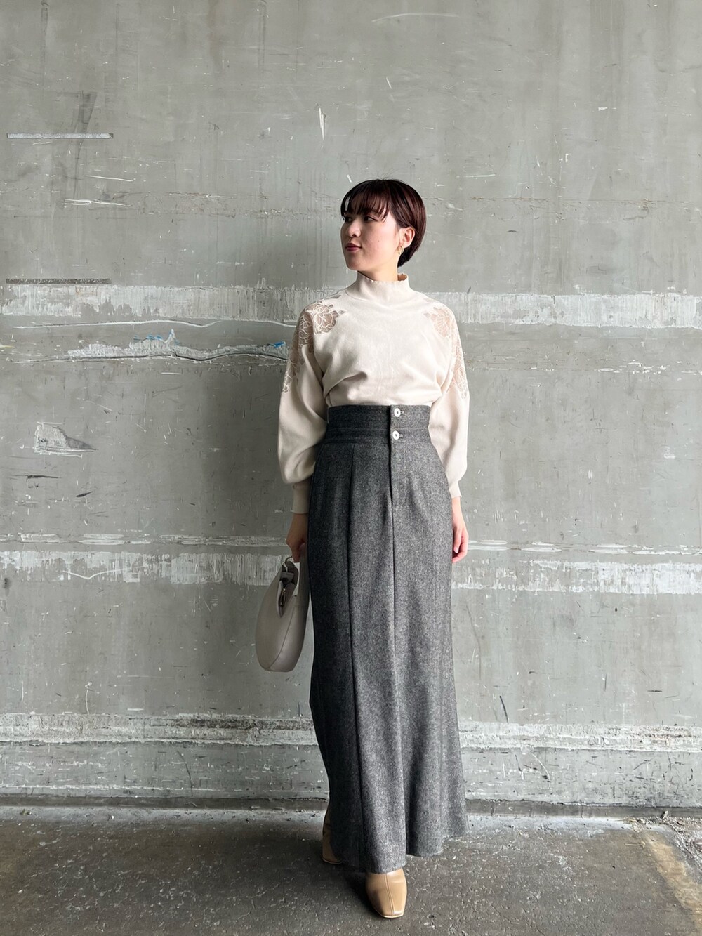 ブラウン系のスカート、ブラウン系のテーラードジャケット、ホワイト系のハンドバッグを着用したレディースの秋コーディネートの7枚目の写真