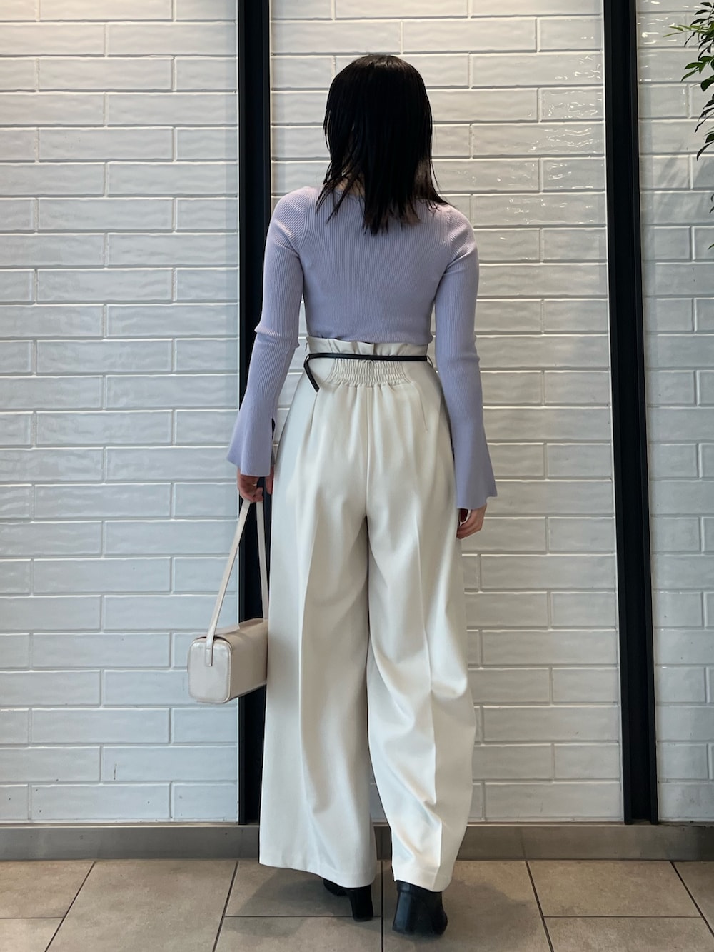 パープル系のニット/セーター、ホワイト系のその他パンツを着用したレディースの冬コーディネートの2枚目の写真