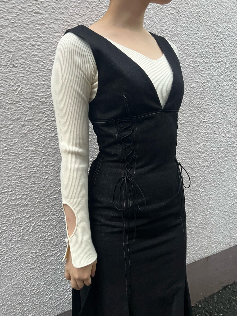 ブラック系のハンドバッグ、ブラック系のワンピース、ホワイト系のニット/セーターを着用したレディースの秋コーディネートの7枚目の写真