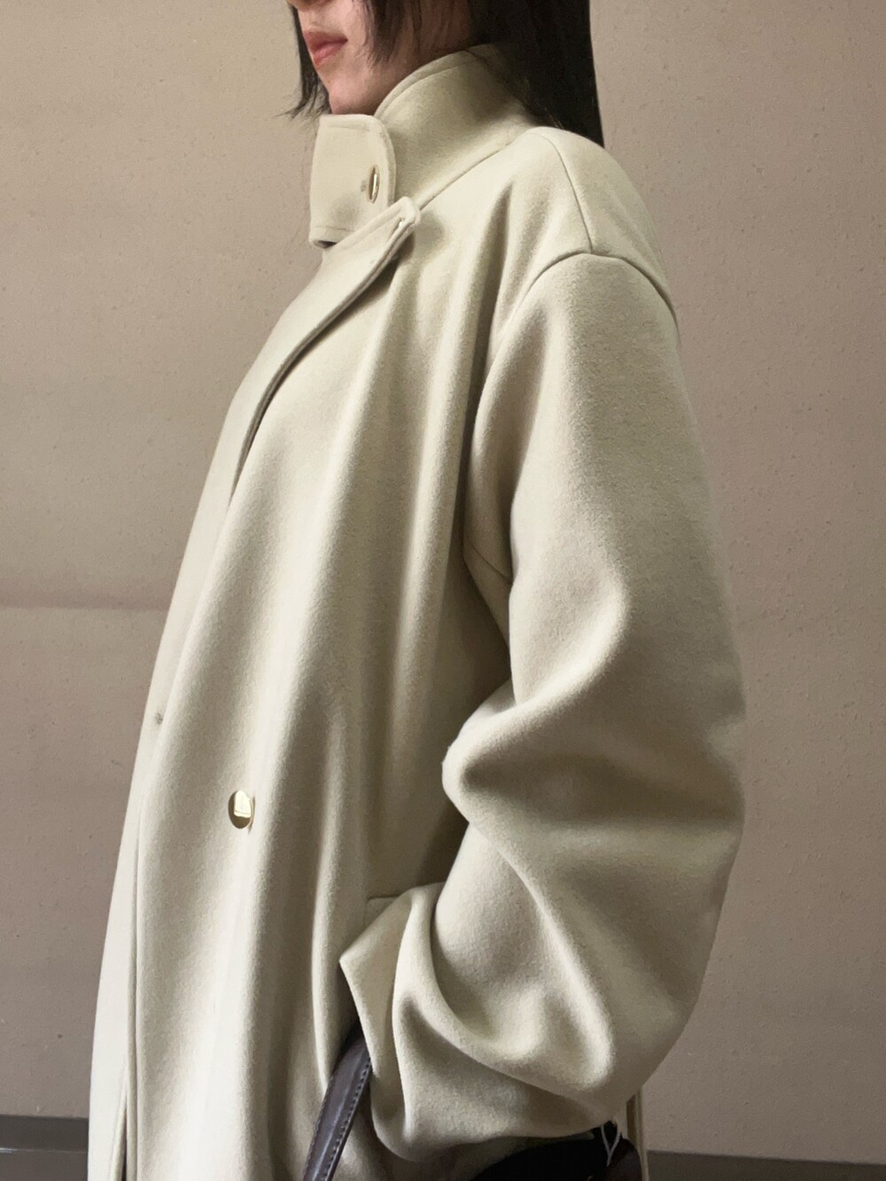 グリーン系のチェスターコート、ブラウン系のハンドバッグ、ブラウン系のその他パンツを着用したレディースの秋コーディネートの5枚目の写真