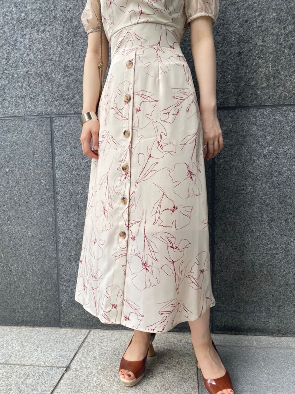 ブラウン系のパンプス、ベージュ系のショルダーバッグ、ホワイト系のワンピースを着用したレディースの夏コーディネートの4枚目の写真