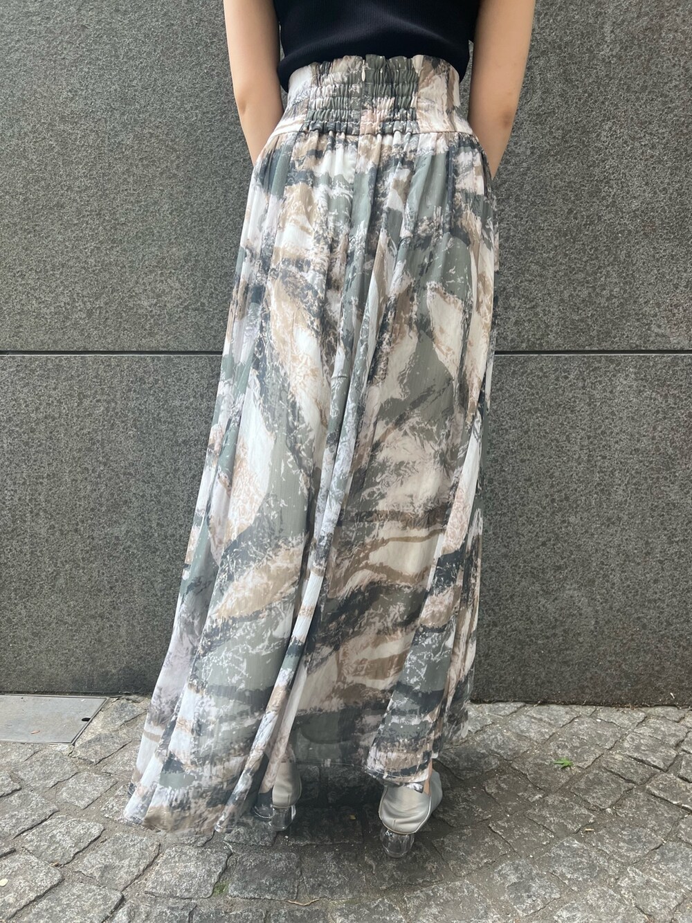 ブラック系のニット/セーター、グレー系のスカート、ブラック系のショルダーバッグを着用したレディースの春コーディネートの9枚目の写真