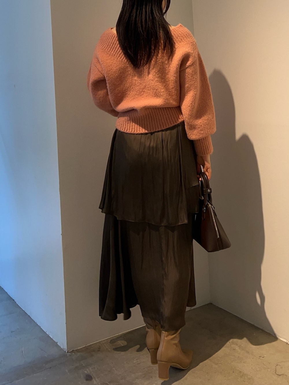 ピンク系のニット/セーター、ベージュ系のブーツ、ブラウン系のスカートを着用したレディースの秋コーディネートの3枚目の写真