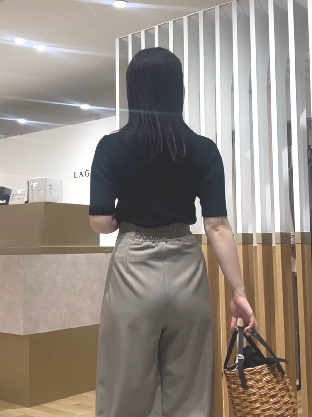 ブラック系のTシャツ/カットソー、ブラウン系のその他パンツ、ブラック系のサンダルを着用したレディースの春コーディネートの6枚目の写真