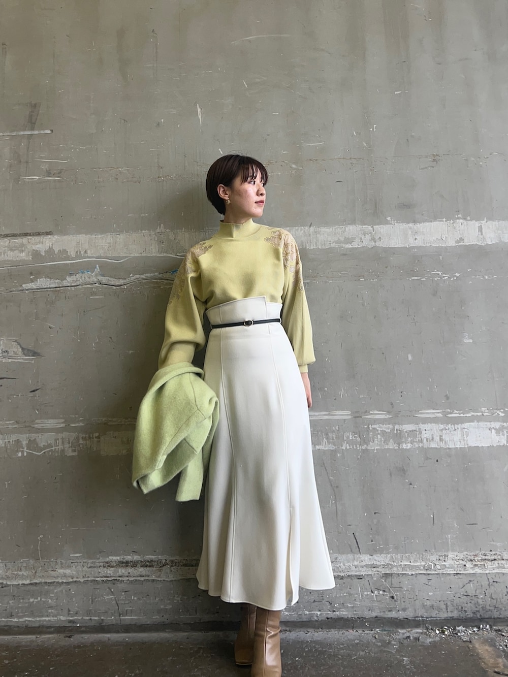 ベージュ系のブーツ、イエロー系のニット/セーター、グリーン系のカーディガン/ボレロを着用したレディースの秋コーディネートの3枚目の写真