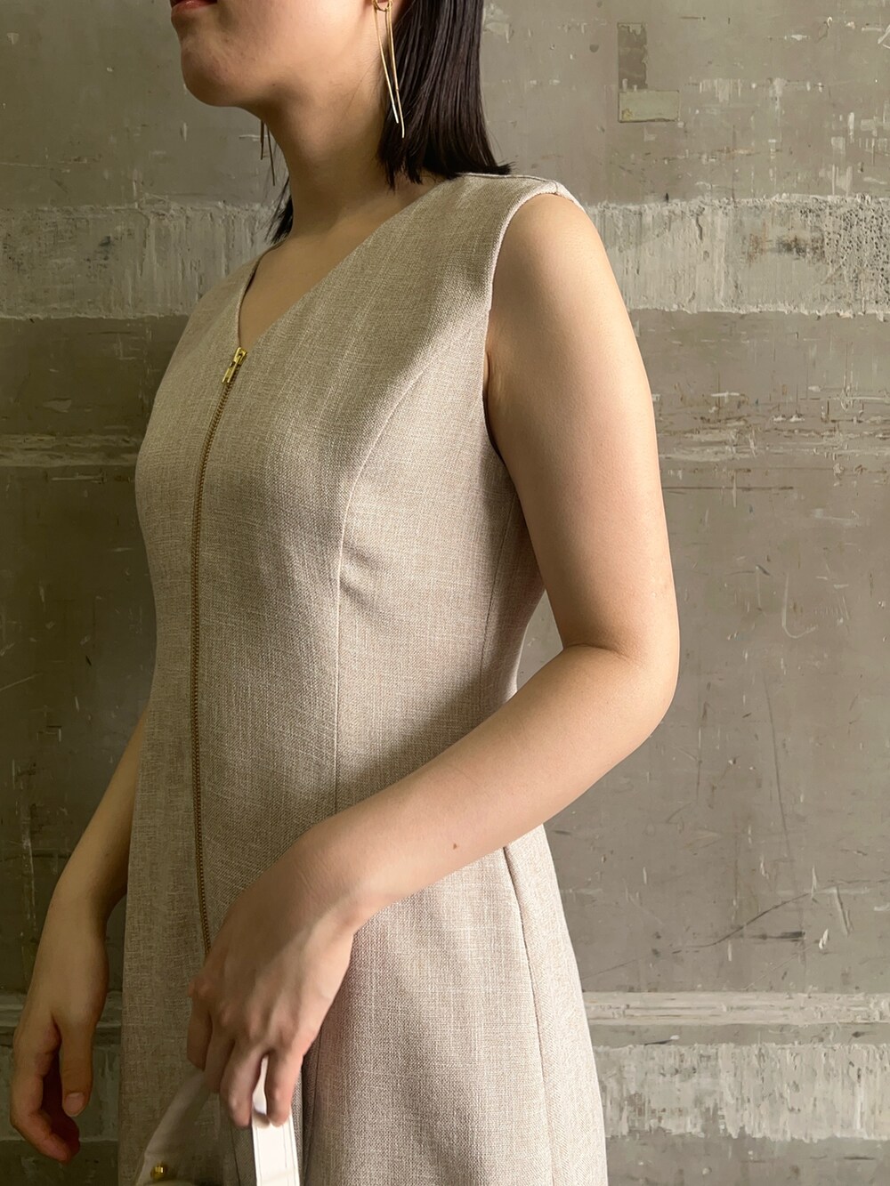 ブラック系のサンダル、ホワイト系のショルダーバッグ、ベージュ系のワンピースを着用したレディースの夏コーディネートの5枚目の写真