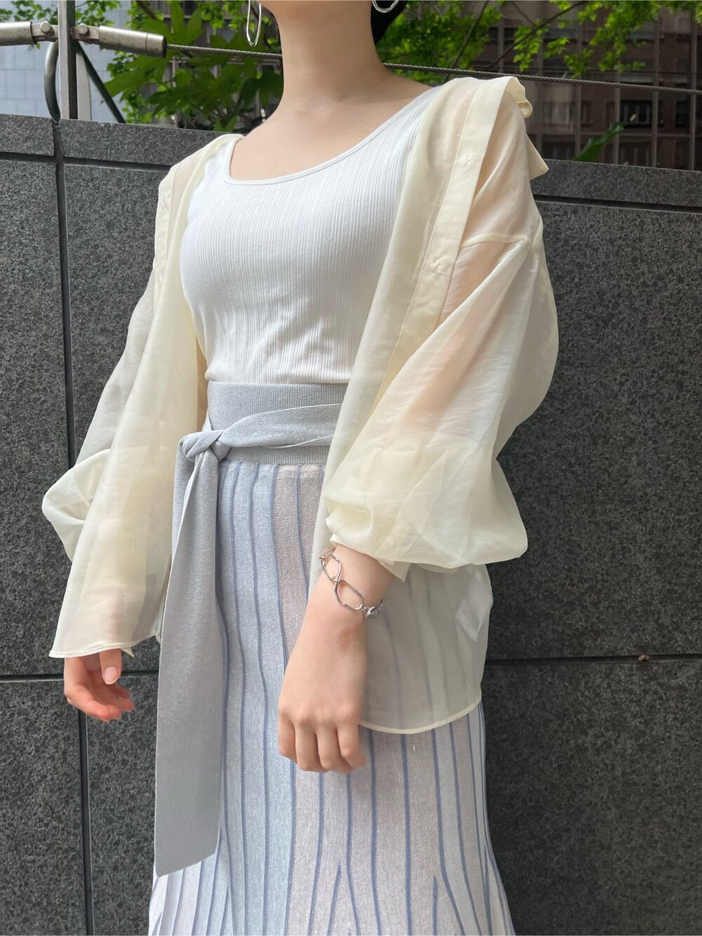 ホワイト系のシャツ/ブラウス、ブルー系のスカート、ブラウン系のパンプスを着用したレディースの春コーディネートの5枚目の写真