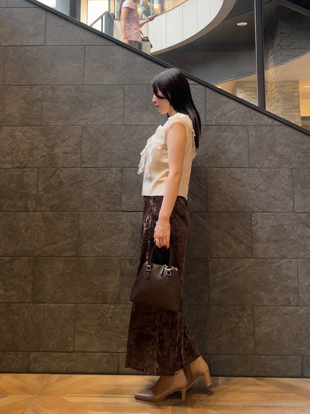 ブラウン系のボストンバッグ、ホワイト系のニット/セーター、ベージュ系のブーツを着用したレディースの秋コーディネートの2枚目の写真