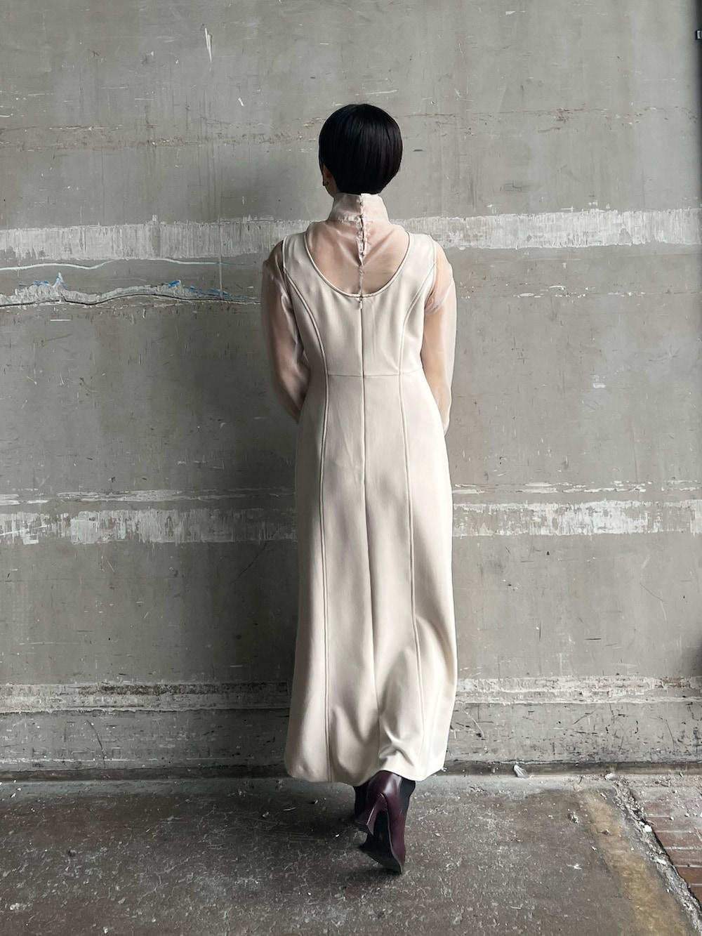 ホワイト系のカーディガン/ボレロ、ホワイト系のジャンパースカート、ベージュ系のシャツ/ブラウスを着用したレディースの秋コーディネートの5枚目の写真