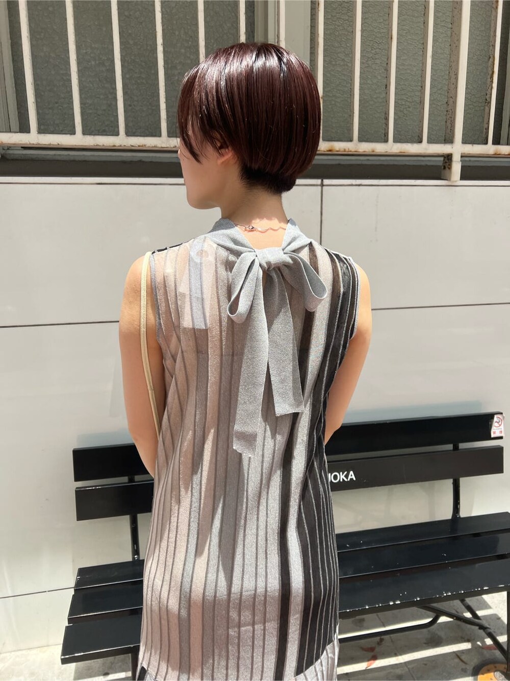 ホワイト系のハンドバッグ、グリーン系のサンダル、ブラック系のワンピースを着用したレディースの夏コーディネートの4枚目の写真