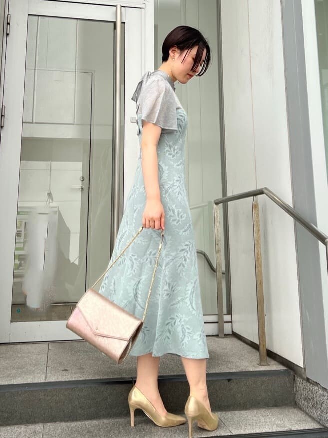 ゴールド系のクラッチバッグ、ゴールド系のパンプス、ブルー系のドレスを着用したレディースの秋コーディネートの3枚目の写真