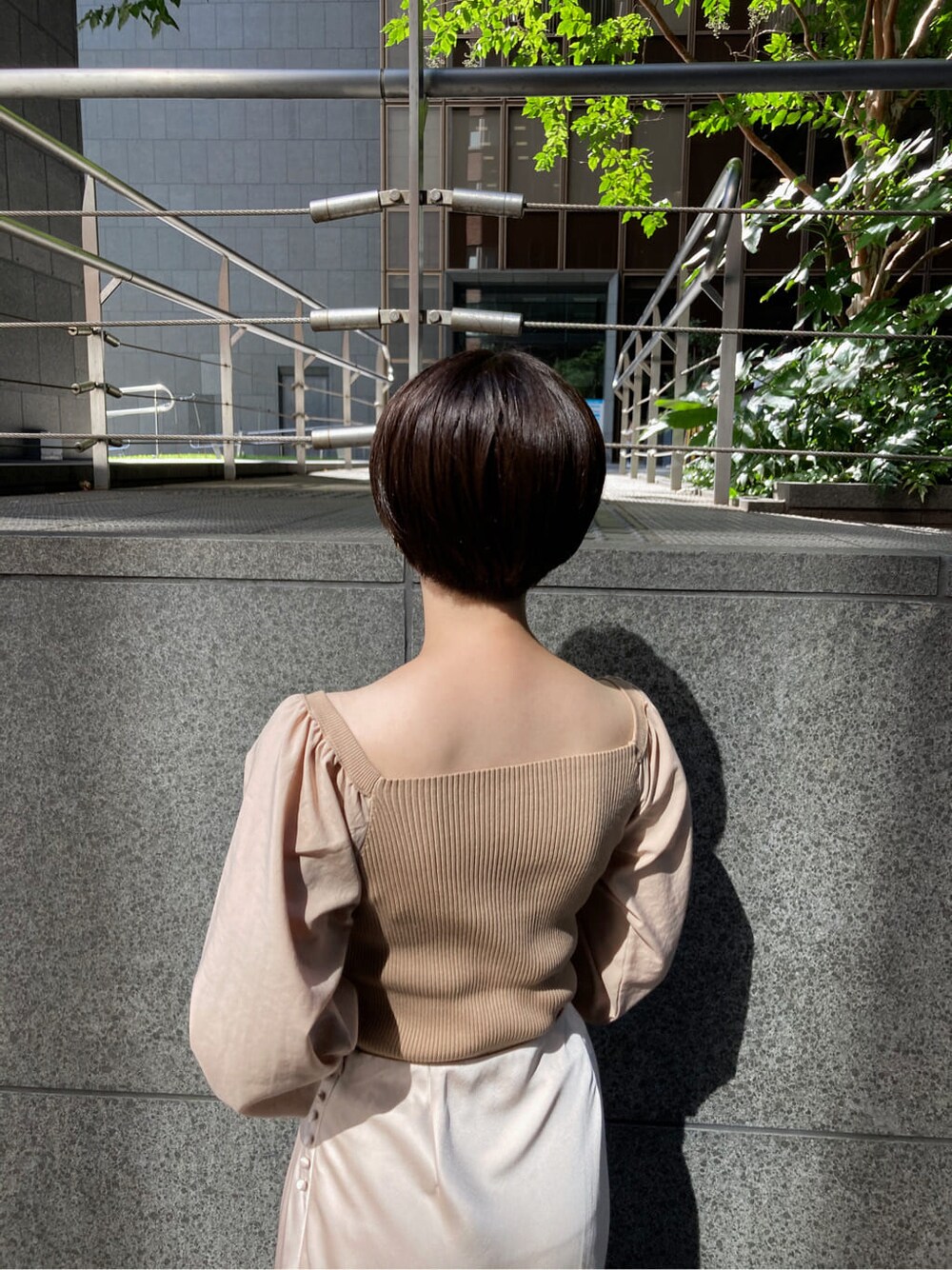 ホワイト系のスカート、ベージュ系のブーツ、ブラウン系のショルダーバッグを着用したレディースの秋コーディネートの5枚目の写真