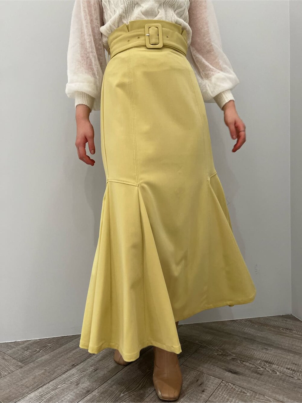 ベージュ系のその他シューズ、ホワイト系のニット/セーター、イエロー系のスカートを着用したレディースの冬コーディネートの5枚目の写真