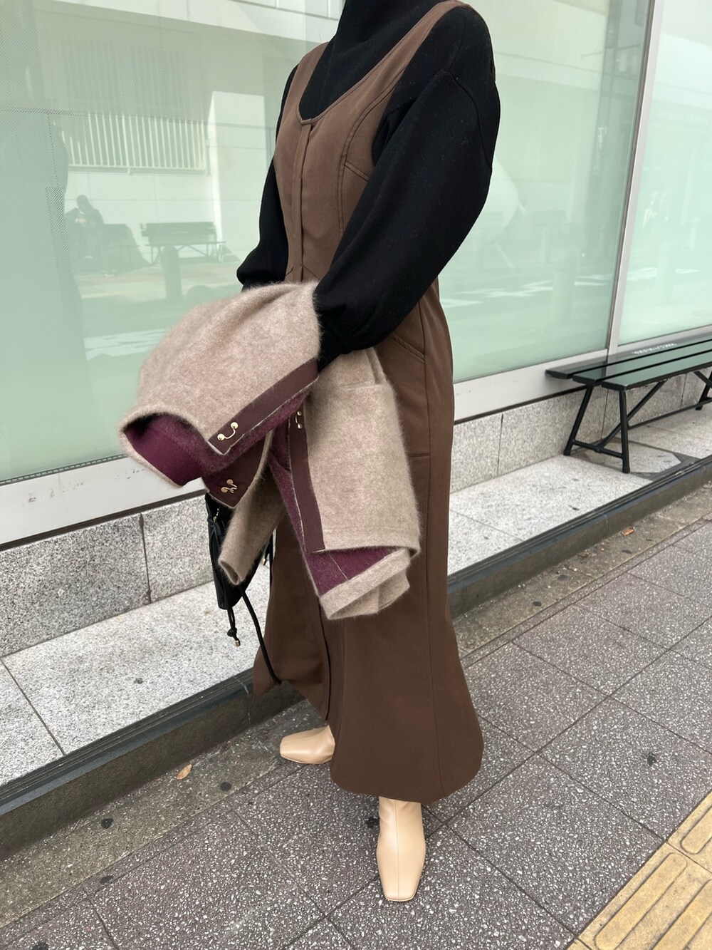 ブラック系のハンドバッグ、ベージュ系のブーツ、ベージュ系のカーディガン/ボレロを着用したレディースの秋コーディネートの8枚目の写真