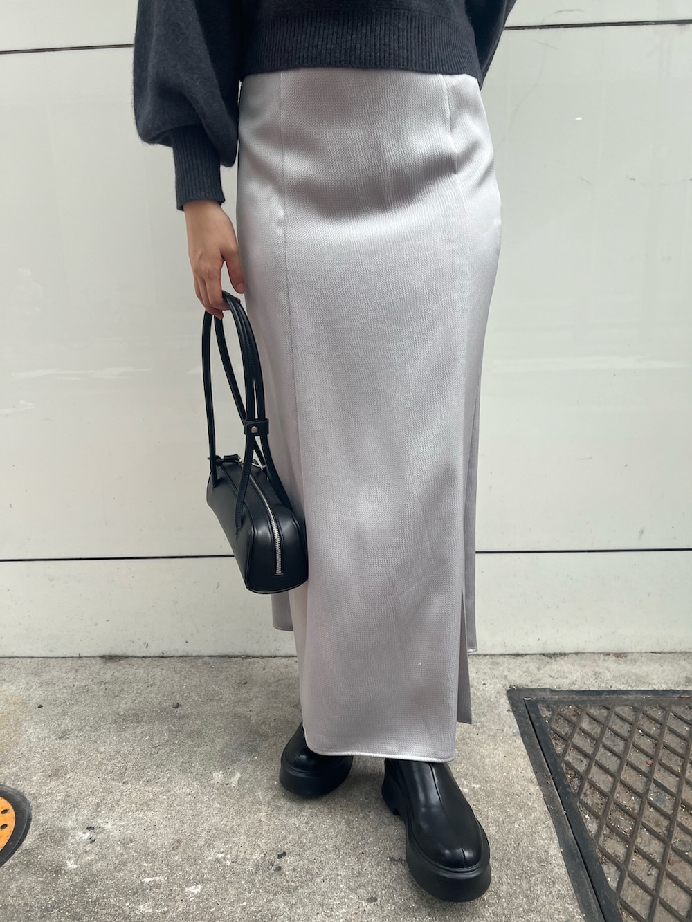 グレー系のニット/セーター、グレー系のカーディガン/ボレロ、ブラック系のスカートを着用したレディースの秋コーディネートの5枚目の写真