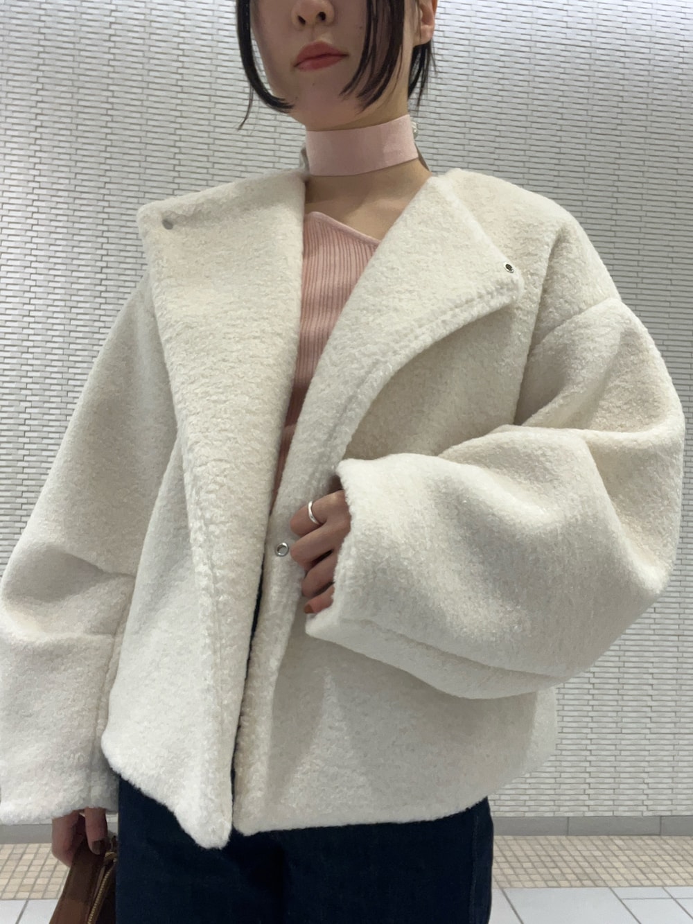 ブルー系のデニムパンツ、ホワイト系のブルゾン、ピンク系のニット/セーターを着用したレディースの冬コーディネートの4枚目の写真