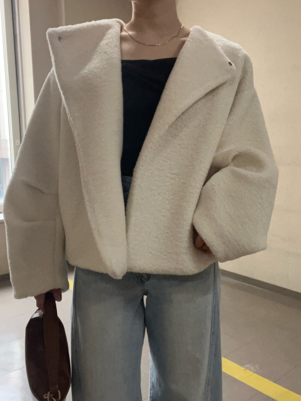 ブルー系のデニムパンツ、ホワイト系のブルゾン、ブラウン系のニット/セーターを着用したレディースの冬コーディネートの4枚目の写真