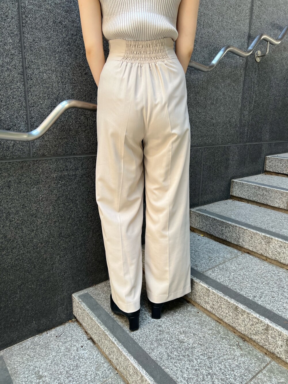 ブラック系のショルダーバッグ、ブラック系のブーツ、ホワイト系のスラックスを着用したレディースの秋コーディネートの10枚目の写真