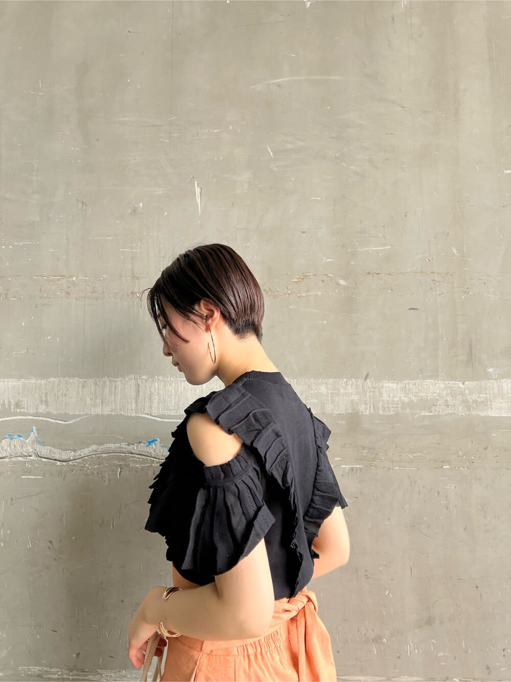 オレンジ系のスカート、その他のパンプス、ブラック系のニット/セーターを着用したレディースの春コーディネートの4枚目の写真