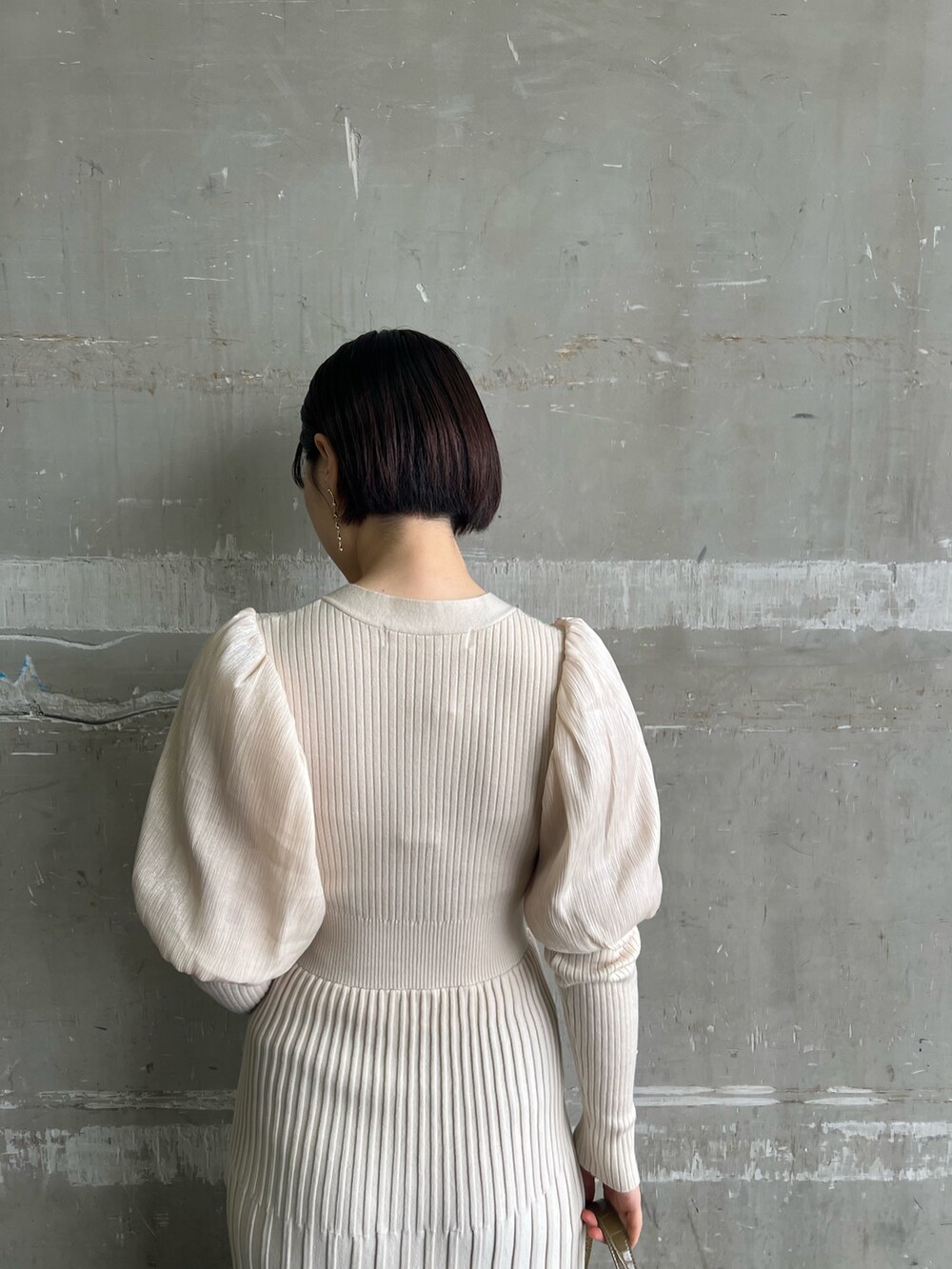 ベージュ系のブーツ、ホワイト系のワンピース、ベージュ系のハンドバッグを着用したレディースの冬コーディネートの6枚目の写真