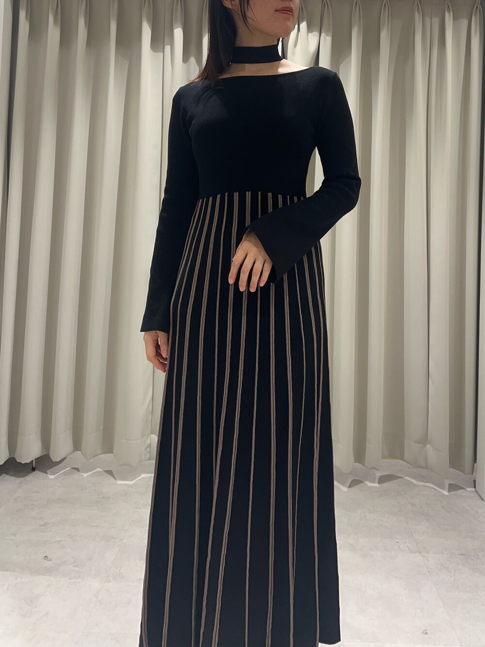 ブラック系のワンピース、ブラック系のブーツを着用したレディースの秋コーディネートの4枚目の写真