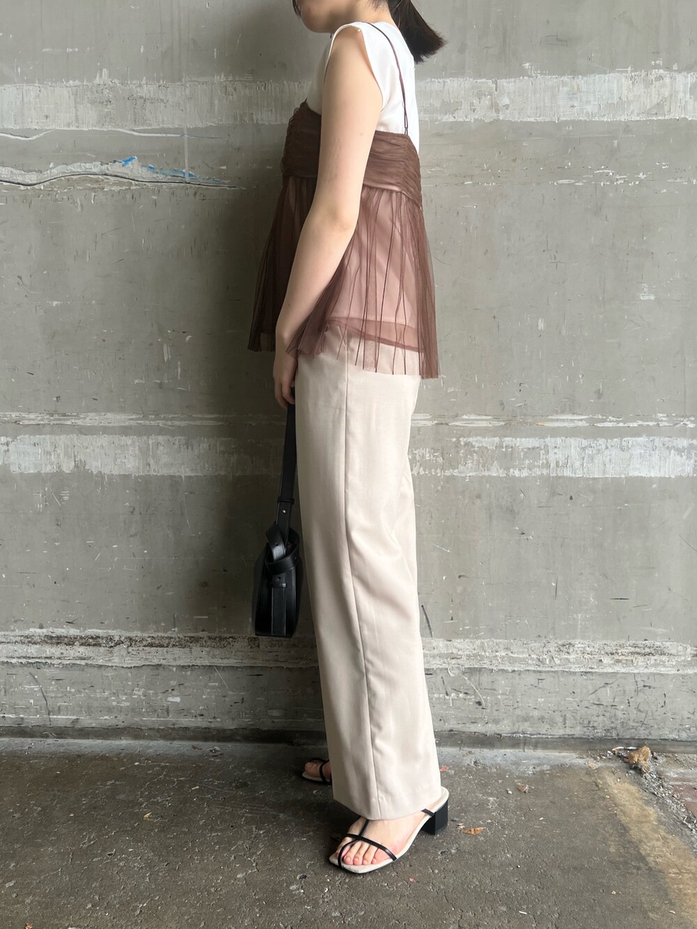 ブラック系のサンダル、ブラック系のショルダーバッグ、ホワイト系のスラックスを着用したレディースの夏コーディネートの8枚目の写真