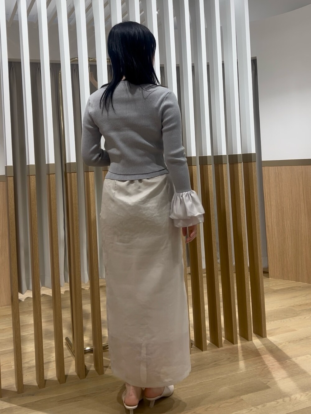 ホワイト系のスカート、グレー系のアンサンブル、ホワイト系のサンダルを着用したレディースの春コーディネートの3枚目の写真