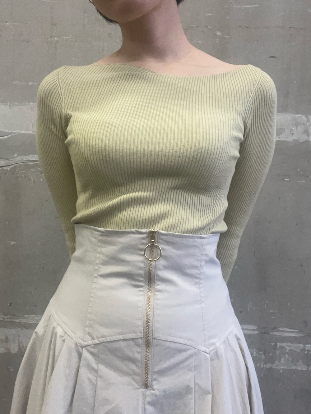 ベージュ系のブーツ、ホワイト系のスカート、グリーン系のニット/セーターを着用したレディースの冬コーディネートの6枚目の写真