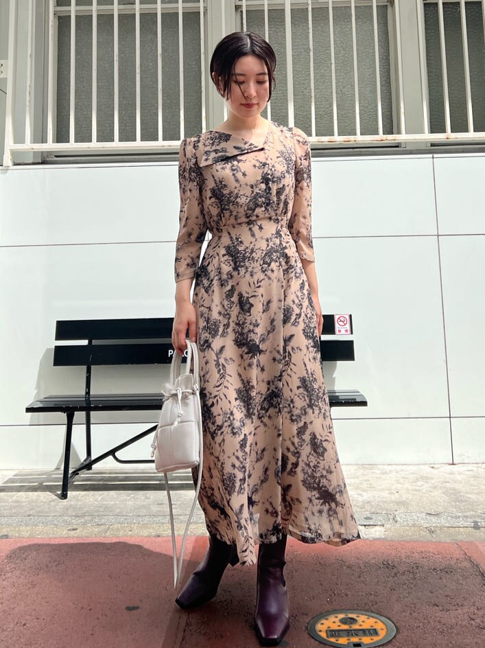 レッド系のブーツ、ホワイト系のカーディガン/ボレロ、ホワイト系のハンドバッグを着用したレディースの秋コーディネートの5枚目の写真